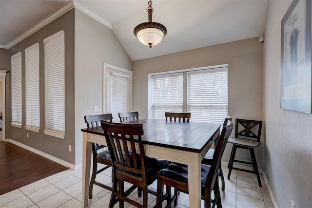 tiled dining room with vaulted ceiling and crown molding