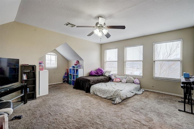 bedroom with ceiling fan, lofted ceiling, carpet, and a textured ceiling