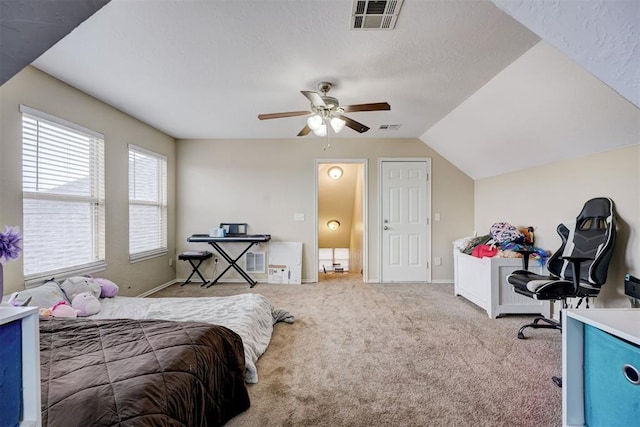 bedroom featuring ceiling fan, lofted ceiling, light colored carpet, and a textured ceiling