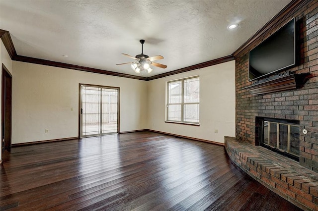 unfurnished living room featuring dark hardwood / wood-style flooring, crown molding, a fireplace, and a textured ceiling