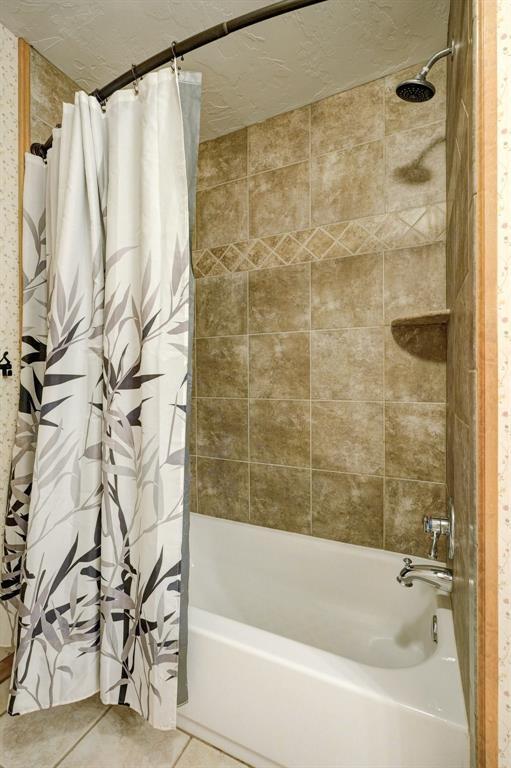 bathroom with tile patterned floors and shower / tub combo