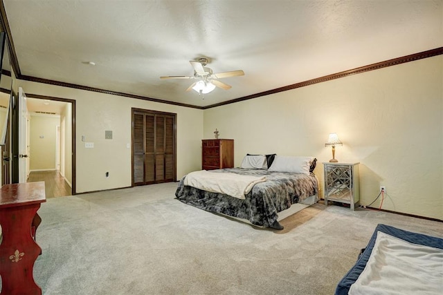 bedroom with ornamental molding, a closet, ceiling fan, and carpet