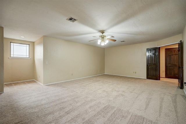 empty room featuring light carpet, a textured ceiling, and ceiling fan