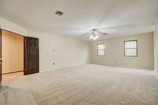 carpeted spare room featuring ceiling fan and a textured ceiling