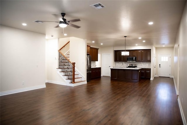 kitchen featuring appliances with stainless steel finishes, dark hardwood / wood-style floors, tasteful backsplash, hanging light fixtures, and a center island