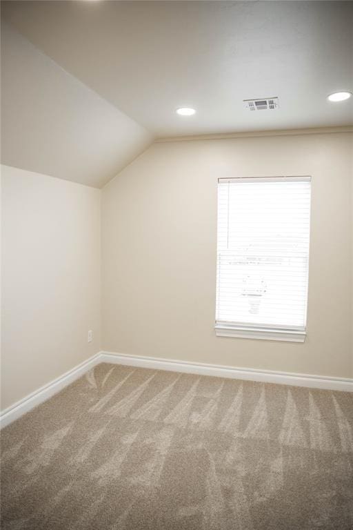 additional living space featuring carpet flooring and vaulted ceiling