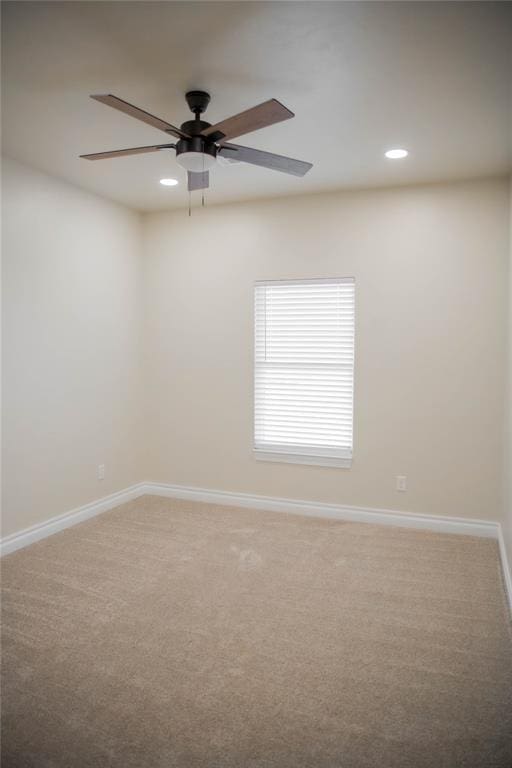 carpeted spare room with ceiling fan