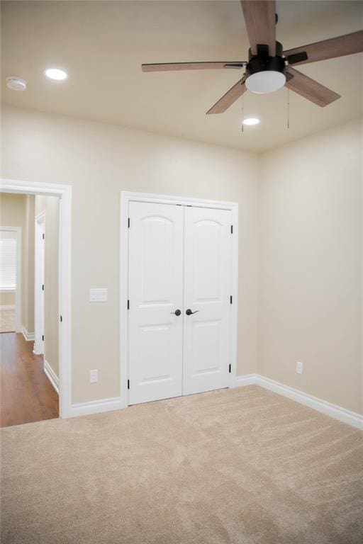 unfurnished bedroom featuring carpet, ceiling fan, and a closet