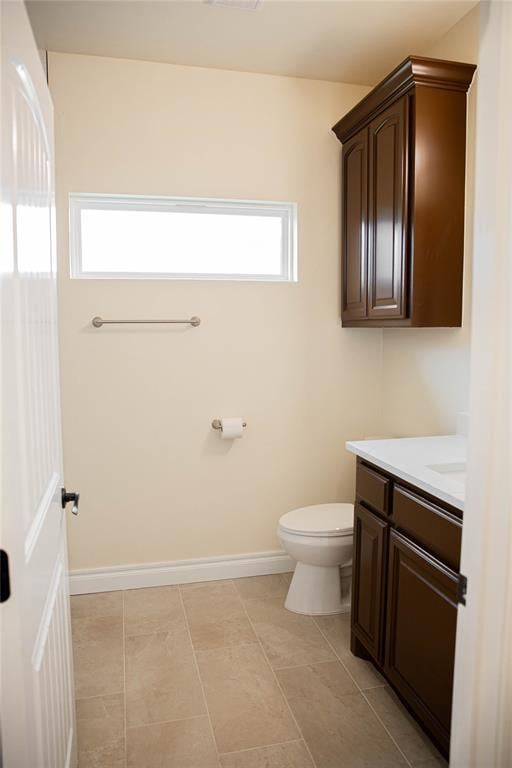 bathroom with tile patterned flooring, vanity, and toilet