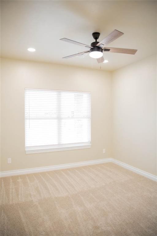 carpeted spare room featuring ceiling fan