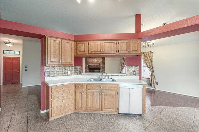 kitchen with sink, light tile patterned floors, dishwasher, decorative backsplash, and kitchen peninsula