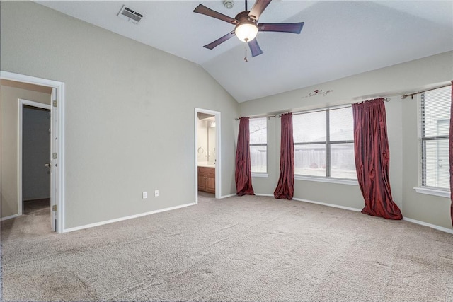 unfurnished bedroom with ceiling fan, ensuite bathroom, vaulted ceiling, and light carpet