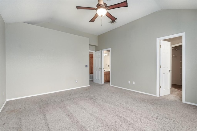 unfurnished bedroom with ceiling fan, lofted ceiling, light colored carpet, and ensuite bath