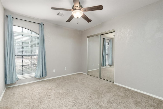 unfurnished bedroom with carpet flooring, ceiling fan, and a closet