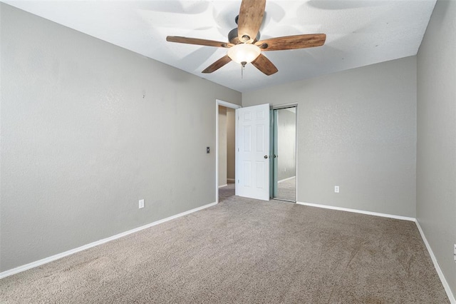 carpeted spare room featuring ceiling fan