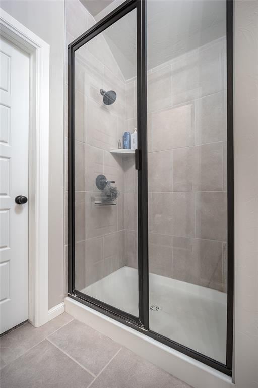 bathroom featuring tile patterned flooring and a shower with door