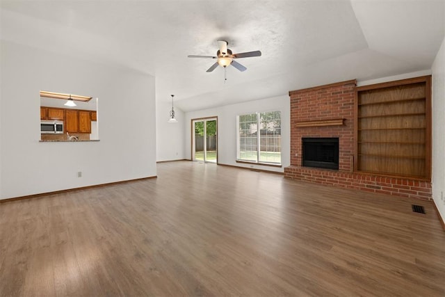 unfurnished living room featuring a fireplace, dark hardwood / wood-style floors, and ceiling fan