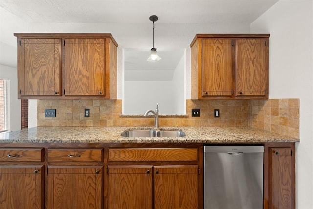 kitchen featuring tasteful backsplash, sink, decorative light fixtures, and stainless steel dishwasher