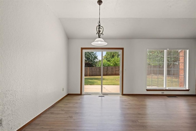 empty room with wood-type flooring and vaulted ceiling