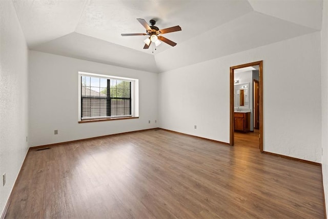 unfurnished room featuring ceiling fan, dark hardwood / wood-style floors, and vaulted ceiling