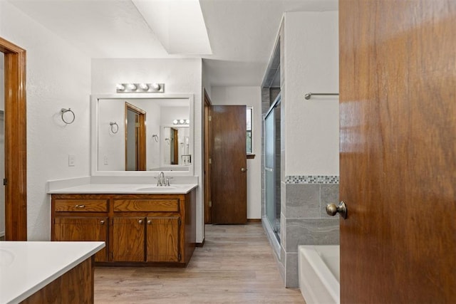 bathroom featuring hardwood / wood-style flooring, vanity, and separate shower and tub