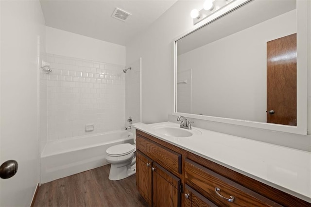 full bathroom featuring vanity, hardwood / wood-style floors, toilet, and tiled shower / bath