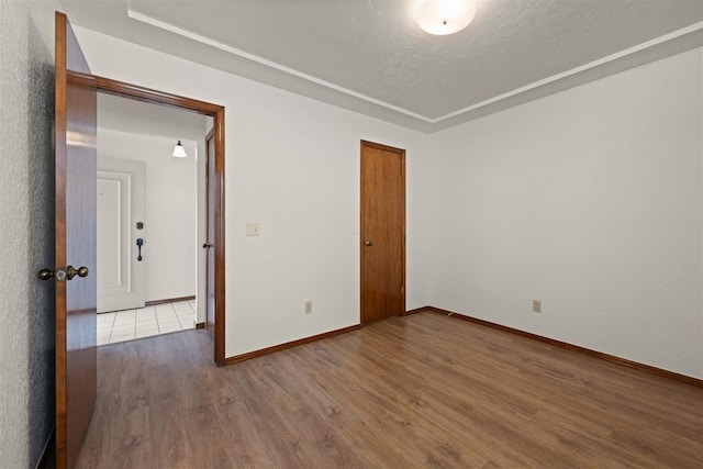 empty room with hardwood / wood-style flooring and a textured ceiling