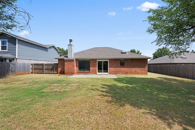 back of property with a lawn and a patio area