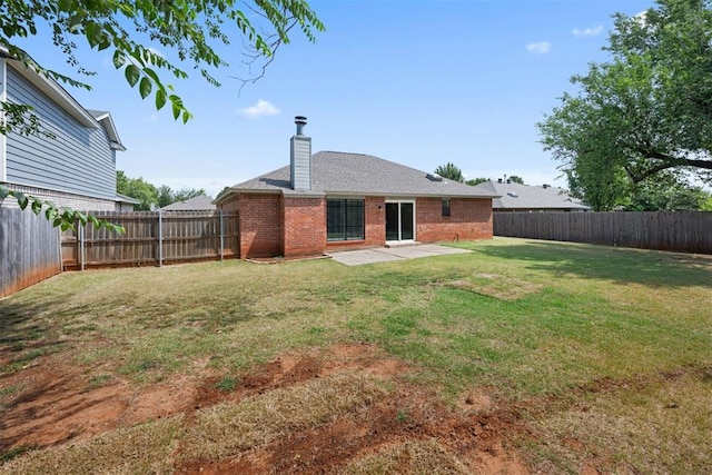 back of house with a lawn and a patio