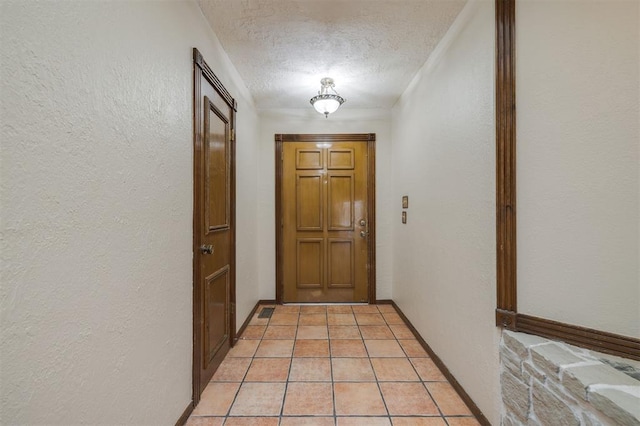 doorway to outside with a textured ceiling and light tile patterned floors