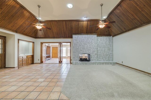 unfurnished living room with a stone fireplace, high vaulted ceiling, light tile patterned floors, ceiling fan, and wood ceiling