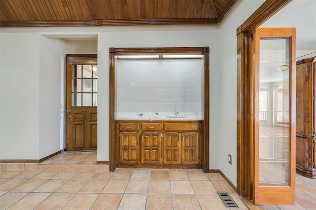 corridor featuring ornamental molding, sink, light tile patterned floors, and wooden ceiling