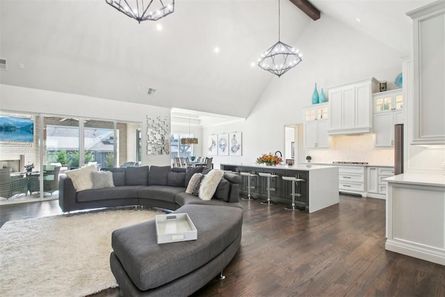 living room with beamed ceiling, visible vents, dark wood-type flooring, high vaulted ceiling, and a chandelier