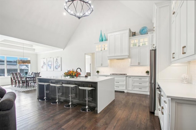 kitchen featuring a notable chandelier, appliances with stainless steel finishes, an island with sink, and light countertops