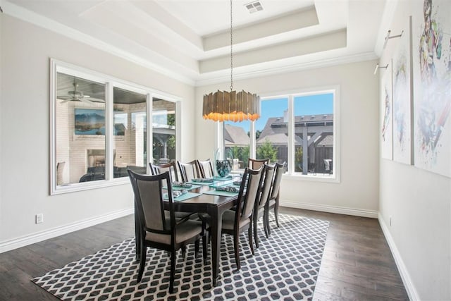 dining area with a raised ceiling, dark wood-style floors, visible vents, and baseboards