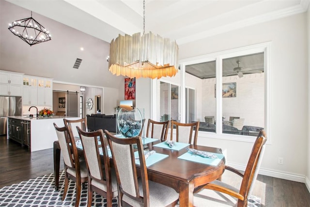 dining room featuring visible vents, ceiling fan with notable chandelier, a barn door, baseboards, and dark wood-style flooring