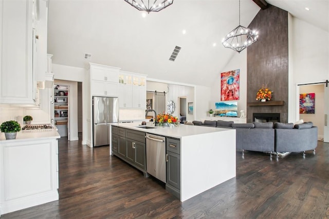 kitchen with stainless steel appliances, light countertops, dark wood-type flooring, and a sink