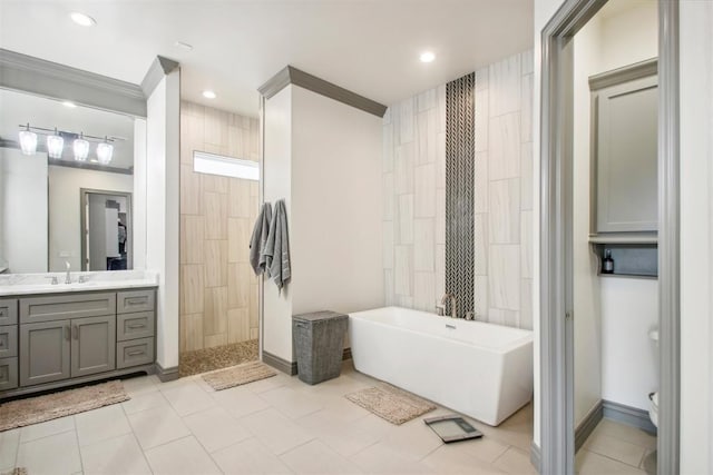 bathroom featuring a freestanding tub, a walk in shower, recessed lighting, tile patterned flooring, and vanity