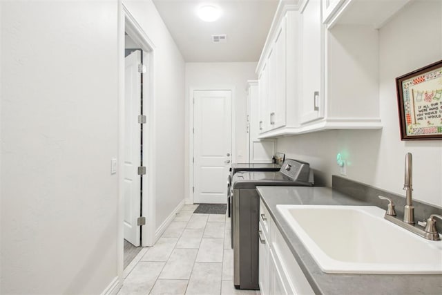 clothes washing area featuring light tile patterned floors, visible vents, cabinet space, a sink, and washer and clothes dryer