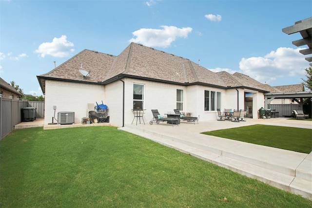 back of property featuring a lawn, roof with shingles, and a fenced backyard