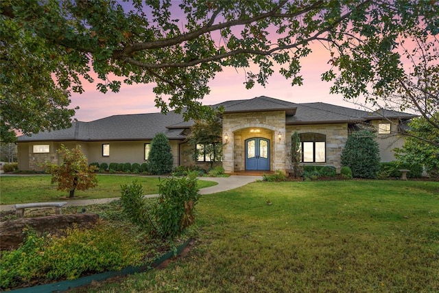 prairie-style house featuring french doors and a lawn