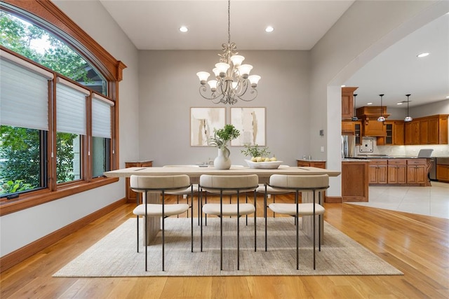 dining space with a notable chandelier and light hardwood / wood-style floors