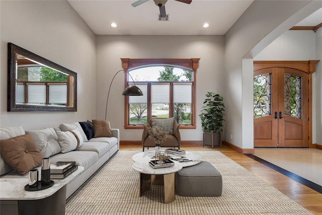 living room featuring light hardwood / wood-style floors, french doors, and ceiling fan