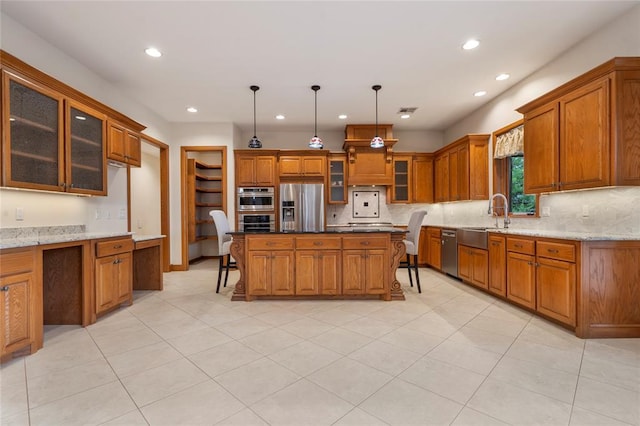 kitchen with a kitchen island, appliances with stainless steel finishes, decorative light fixtures, sink, and light stone counters