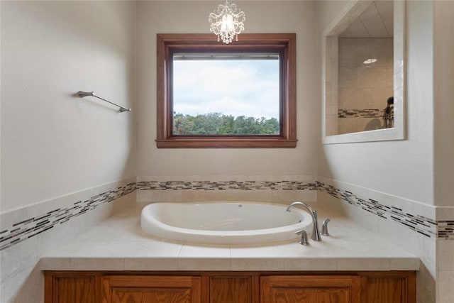 bathroom featuring an inviting chandelier and a bath