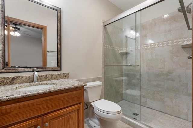 bathroom featuring an enclosed shower, vanity, toilet, and ceiling fan