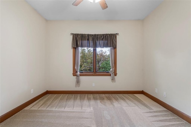 carpeted spare room featuring ceiling fan