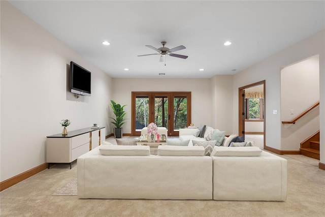 living room with french doors, light colored carpet, and ceiling fan