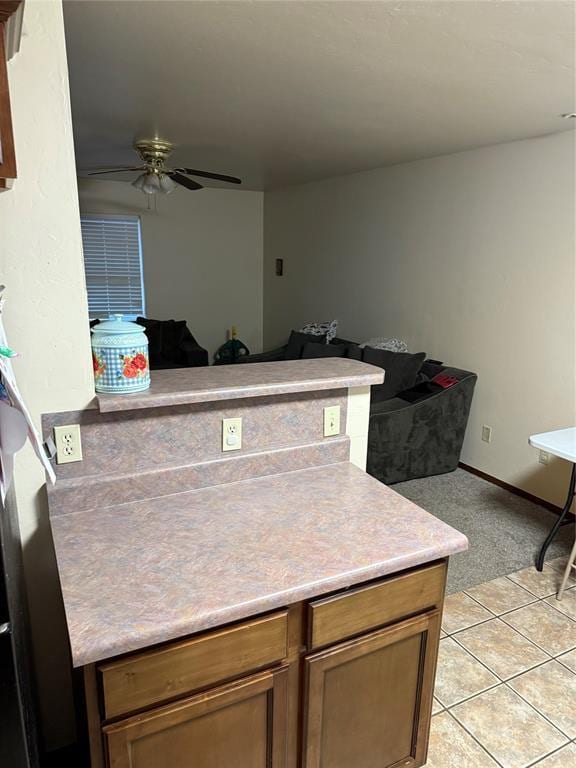 kitchen featuring ceiling fan, kitchen peninsula, and light tile patterned floors