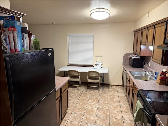 kitchen featuring extractor fan, sink, backsplash, light tile patterned floors, and black appliances